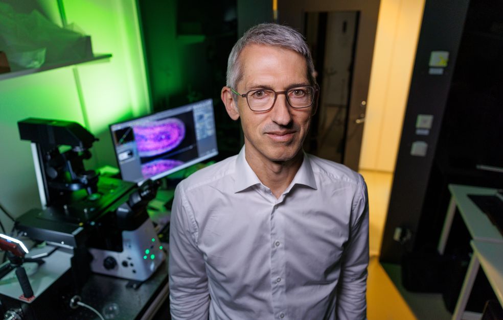 Jan Ellenberg  står i ett laboratorium med experimentell utrustning.