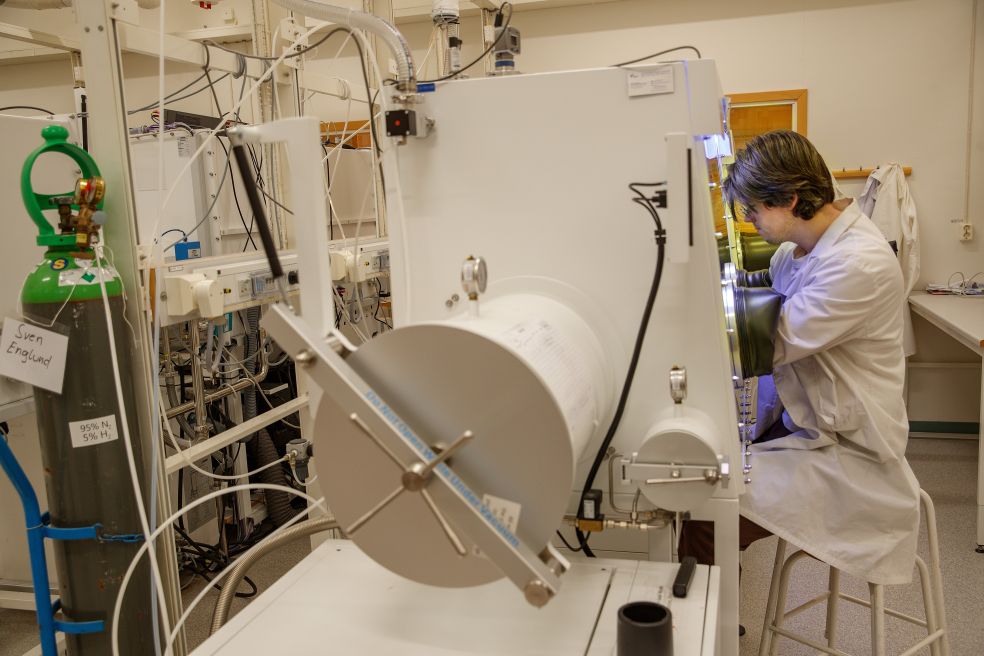 En laboratoriemiljö med en tekniker som arbetar vid en stor apparat.