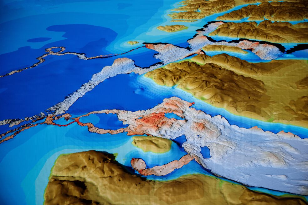Karta över kustlinje med sjöar och fjäll i färgade nyanser av blått och brunt.