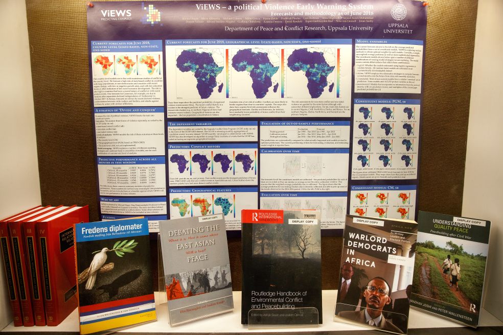 Flera böcker framför en informationsskylt med kartor och diagram om Afrika.
