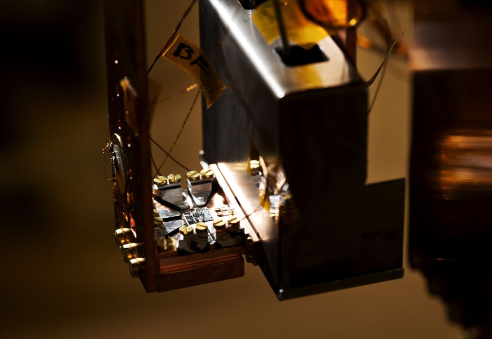 Detalj av en komplex mekanism med ljusinsläpp och metallkomponenter.