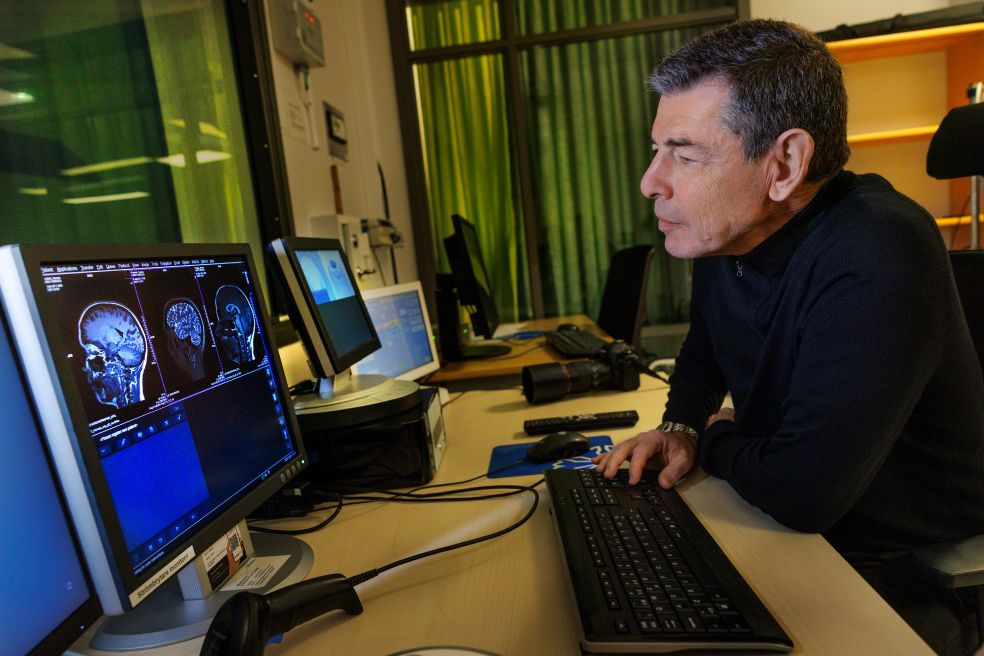 Man som analyserar medicinska bilder på dator i ett modernt kontor.