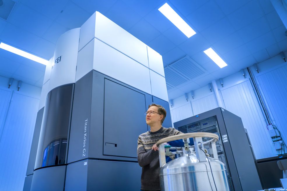 Lars-Anders Carlsson i ett forskningslaboratorium med en stor maskin och en behållare.
