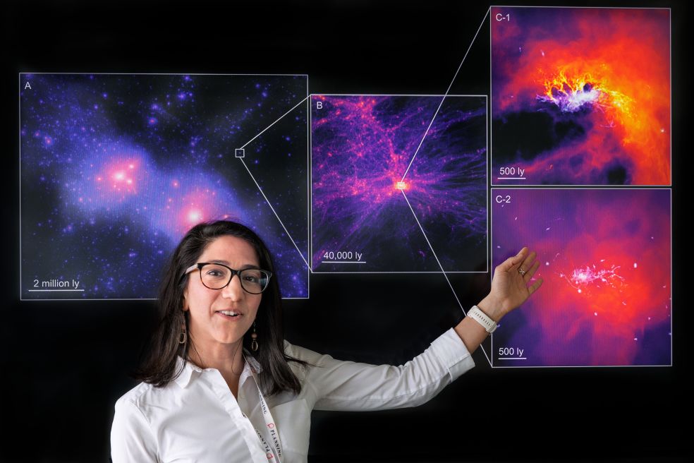Kvinna pekar på kosmiska bilder med färgglada galaxer och nebulosor.