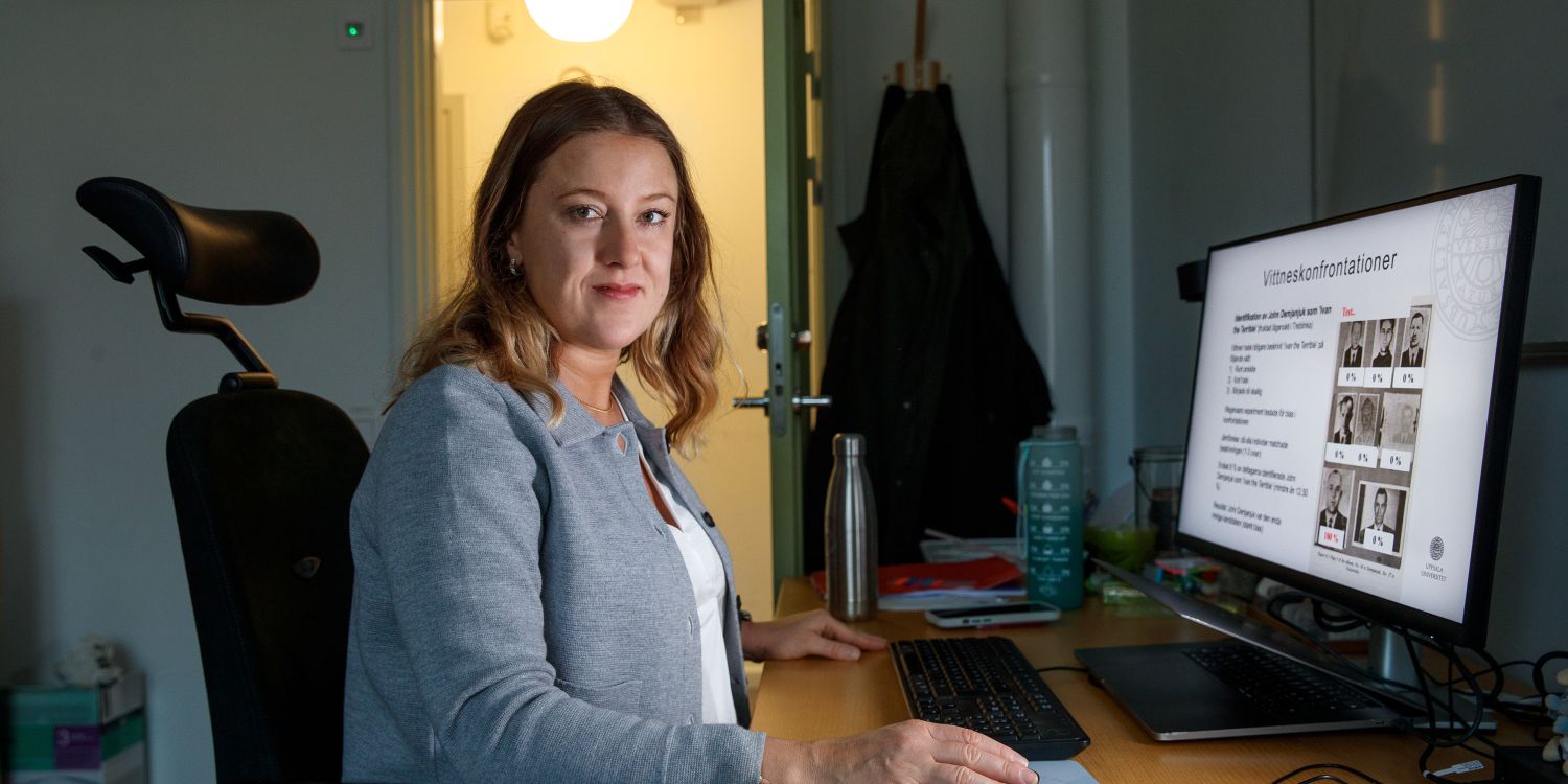 Kvinna sitter vid ett skrivbord med dator, ser fokuserad ut i ett kontor.