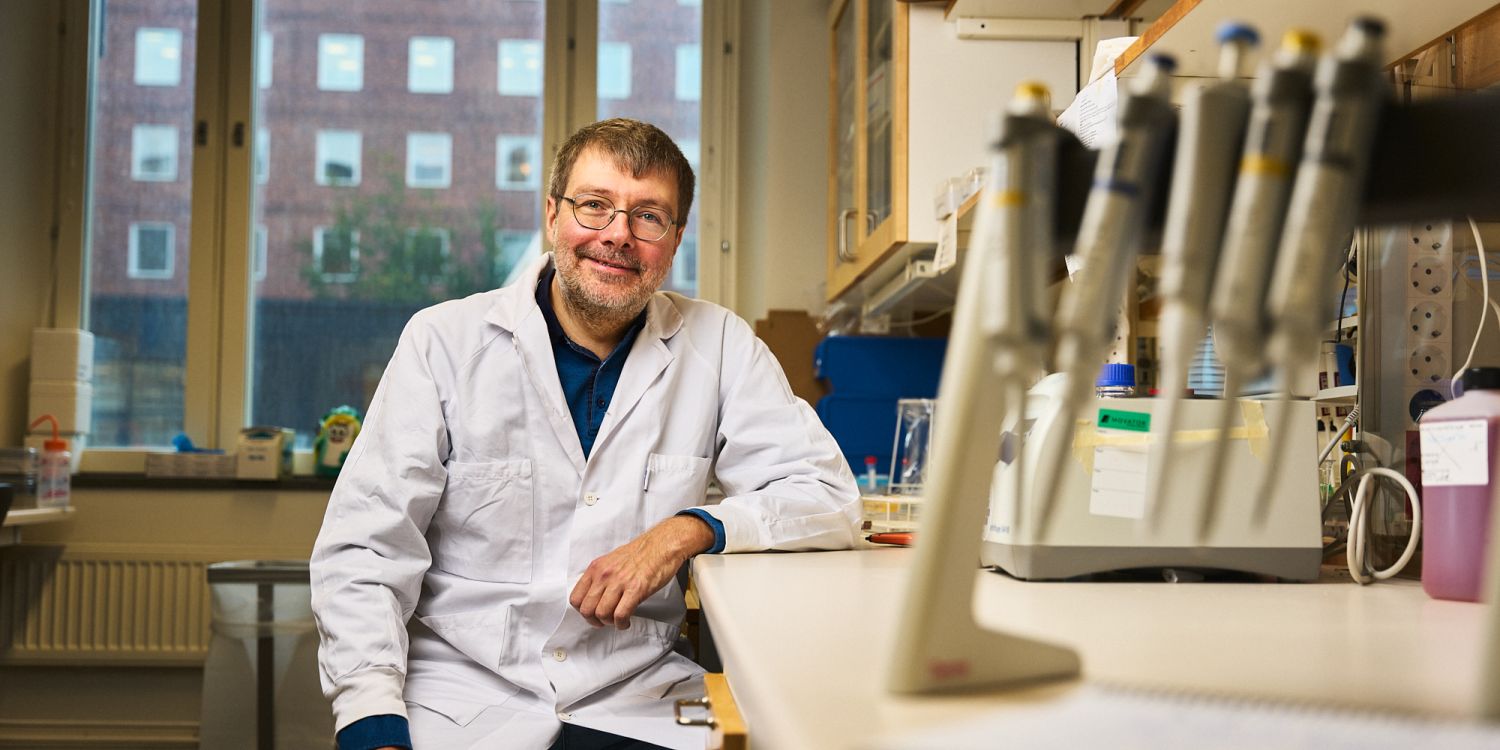 Taras Kreslavsky i labbrock sitter vid ett labbord med pipetter i bakgrunden.
