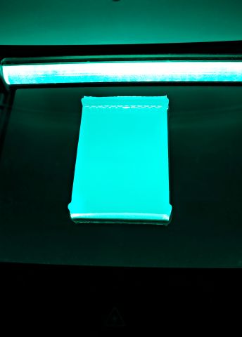 Grön belysning över en vit bok i en scanner.