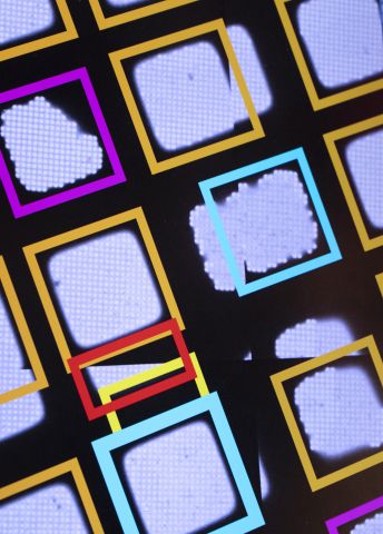 Färgglada ramar i mönster på en svart bakgrund med oklara former.