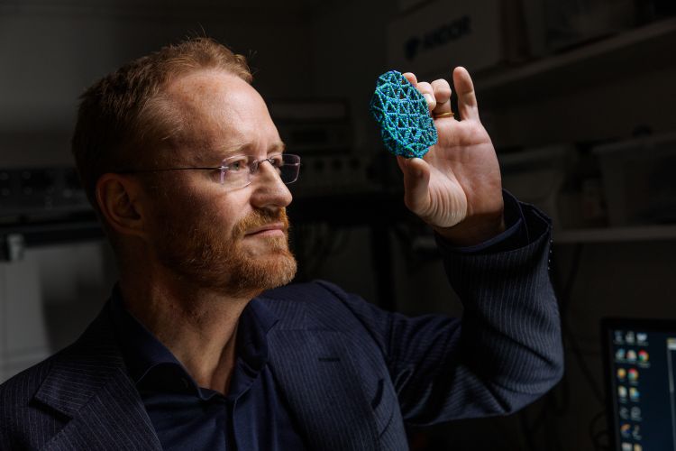 Forskare i skyddsdräkt använder en pipett i ett laboratorium.