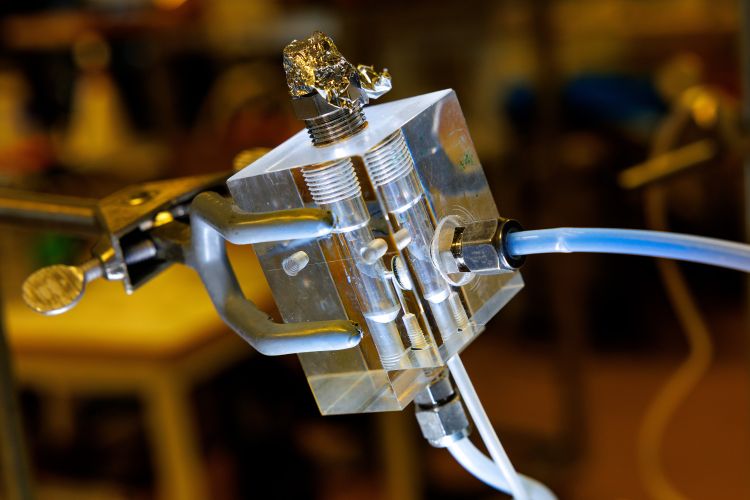 Transparent apparat med rör och klämmor på en laboratoriumsmiljö.