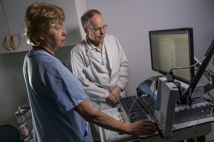 Två medicinska yrkespersoner vid en dator i ett undersökningsrum.