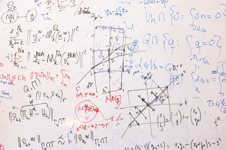 Matematiska formler och grafer skrivna på en vit tavla.