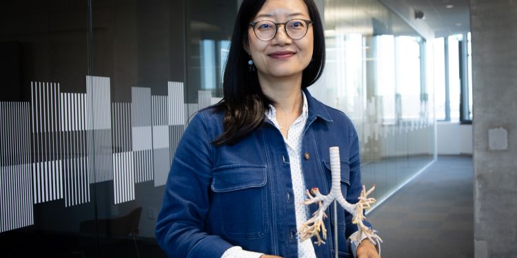 Joan Yuan håller i modell 