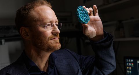 Forskare i skyddsdräkt använder en pipett i ett laboratorium.