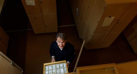 En person står framför sådana lådor och håller en låda med små fack.