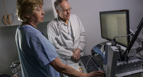 Två medicinska yrkespersoner vid en dator i ett undersökningsrum.